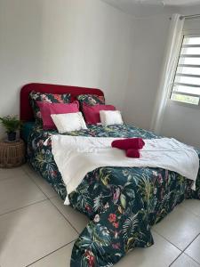 una cama con un osito de peluche rojo sentado encima en Villa KasaLeu, en Saint-Leu