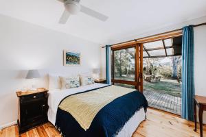 a bedroom with a bed and a large window at Ilkley House - A Refreshing Family Rural Getaway in Eurunderee