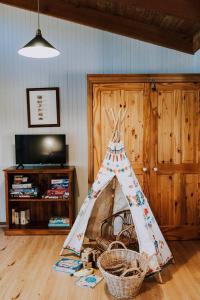 a teepee tent in a room with baskets on the floor at Ilkley House - A Refreshing Family Rural Getaway in Eurunderee