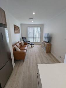 uma sala de estar com um sofá e uma televisão em Bateau Bay Retreat em Bateau Bay