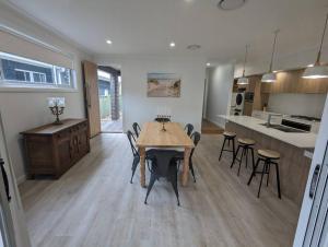 a kitchen and dining room with a table and chairs at Bateau Bay Retreat in Bateau Bay