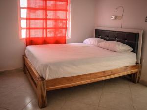 a bed with a wooden frame in a room with a window at VALLE REAL in Turbo
