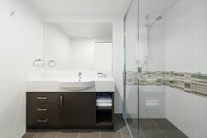a bathroom with a sink, mirror, and bathtub at Property Vine - Pacific Sands, formerly Direct Hotels - Pacific Sands in Mackay