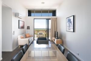 un soggiorno con divano e tavolo da pranzo di Pacific Sands Apartments Mackay a Mackay