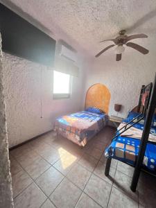 a bedroom with two beds and a ceiling fan at Casa villas del pacifico en puerto San José in Puerto San José