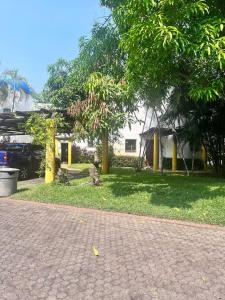 una pasarela de ladrillo frente a una casa con árboles en Casa villas del pacifico en puerto San José en San José de Guatemala