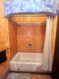 a bathroom with a bath tub with a tiled floor at Casa villas del pacifico en puerto San José in San José de Guatemala