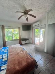 1 dormitorio con 1 cama y ventilador de techo en Casa villas del pacifico en puerto San José, en Puerto San José