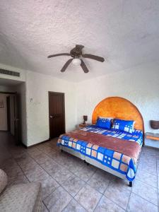 a bedroom with a bed and a ceiling fan at Casa villas del pacifico en puerto San José in Puerto San José