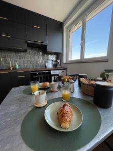 a kitchen with a table with a plate of croissants at TheLighthouse Logement cozy idéalement situé in Calais
