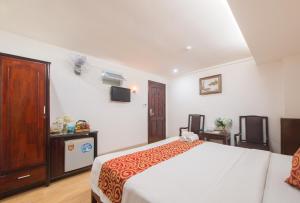een hotelkamer met een bed en een televisie bij LE SOLEIL HOTEL managed by NEST Group in Nha Trang