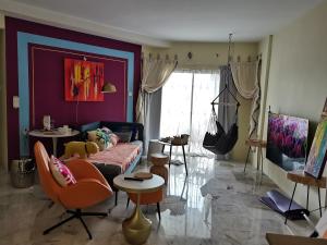 een woonkamer met een bank en stoelen bij Ampang Hilir Lake View - Suite Unit and Rooms in Kuala Lumpur