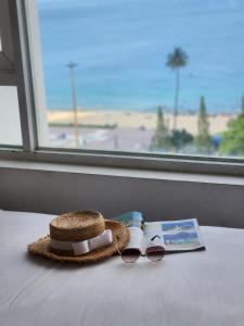 een zonnebril en een boek naast een raam bij LE SOLEIL HOTEL managed by NEST Group in Nha Trang