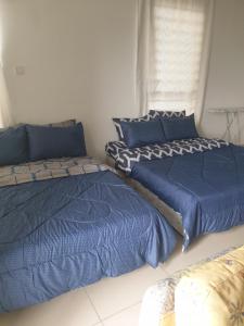 two beds sitting next to each other in a bedroom at I-City Shah Alam Homestay, Studio, 2 Katil Queen, 1 Sofa, Balcony in Kampong Padang Jawa