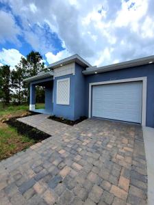a blue house with a garage at Blue life in Lehigh Acres