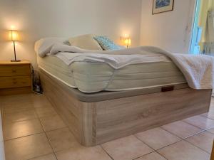 キャヴァレール・シュル・メールにあるLes Lavandiersの木製ベッド1台(マットレス付)