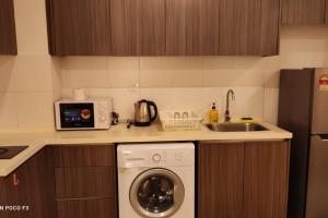 cocina con lavadora y fregadero en HA1605- 2 BEDROOM- WI-FI-NETFLIX-PARKING- CYBERJAYa, 3077, en Cyberjaya