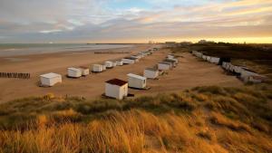 rząd domków plażowych na piaszczystej plaży w obiekcie TheLighthouse Logement cozy idéalement situé w Calais
