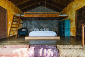 1 dormitorio con cama, escalera y sofá en Baba Yaga Atitlan en San Marcos La Laguna