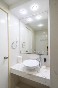 a bathroom with a sink and a large mirror at Napa Jay Hotel in Ayia Napa