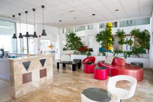 a living room with red chairs and a table at Napa Jay Hotel in Ayia Napa