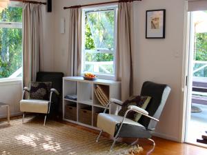sala de estar con 2 sillas y 2 ventanas en Mahakipawa Waterfront Hideaway - Belvue Bay Home, en Linkwater