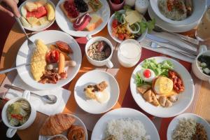 ein Tisch mit vielen Teller Essen drauf in der Unterkunft Aloft Bangkok - Sukhumvit 11 in Bangkok