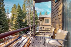 d'un balcon avec des chaises et une vue sur les bois. dans l'établissement Year Round Getaway 301, à Breckenridge