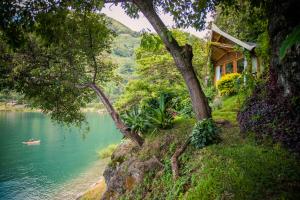 a house on a hill next to a lake at Baba Yaga Atitlan in San Marcos La Laguna