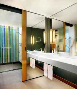 een badkamer met 3 wastafels en een grote spiegel bij Aloft Bangkok - Sukhumvit 11 in Bangkok