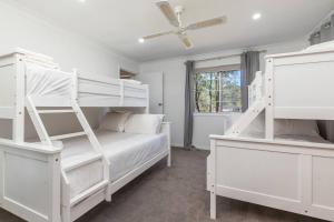 a bedroom with two bunk beds and a ceiling fan at Cundletown Cove in Cundletown +31 photos