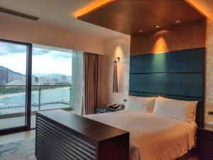 a bedroom with a large bed and a large window at JW Marriott Hotel Sanya Dadonghai Bay in Sanya