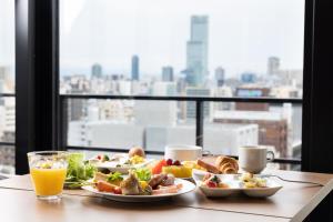 a table with two plates of food and orange juice at the b namba-kuromon in Osaka
