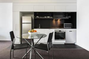 a kitchen with a table and a microwave at Code Apartments in Brisbane