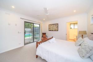 a bedroom with two beds and a sliding glass door at Spacious 3Bd n Pool family holiday home TF2223 in Frankston