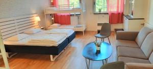 a bedroom with a bed and a couch and a table at Körsbärskullen in Vimmerby
