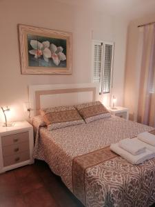 1 dormitorio con 1 cama, 2 mesas y un cuadro en Casa Rosita Relax - Piscina y gran terraza, en Aguadulce
