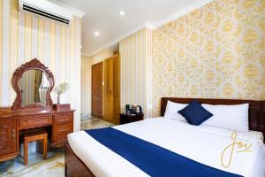 Schlafzimmer mit einem Bett, einer Kommode und einem Spiegel in der Unterkunft Joi Hospitality - KP House in Vũng Tàu