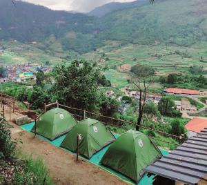 2 tende verdi su una collina che domina una valle di Misty Mountains Holiday Homes a Vattavada