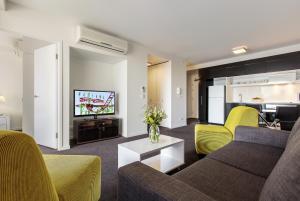 Code Apartments في بريزبين: غرفة معيشة مع أريكة وتلفزيون