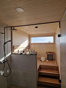 a small bathroom with a shower and a window at Beach house in Kalajoki