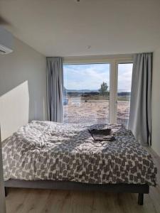 a bedroom with a bed and a large window at Beach house in Kalajoki