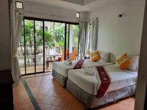 two beds in a room with a balcony at Samui Honey Backpacker Bungalow in Choeng Mon Beach
