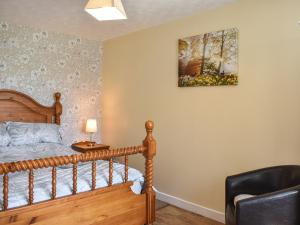 1 dormitorio con 1 cama y una foto en la pared en Glen Nevis Cottage en Port Elphinstone