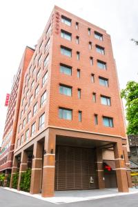 a tall red brick building with a garage at Riverview Suites Taipei in Taipei
