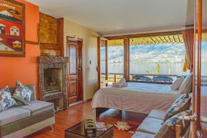 a bedroom with a bed and a fireplace and a window at Campo Lago Hospedaje in Otavalo