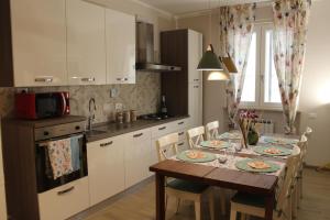 cocina con mesa con sillas y microondas en Aurora BnB, en Pisa