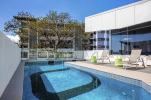 a swimming pool on the roof of a building at Code Apartments in Brisbane