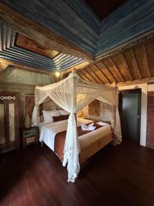 um quarto com uma cama de dossel em Puri Sundaram Villa em Ubud