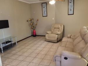 a living room with two chairs and a couch at Lux contractors accommodation in Bronkhorstspruit